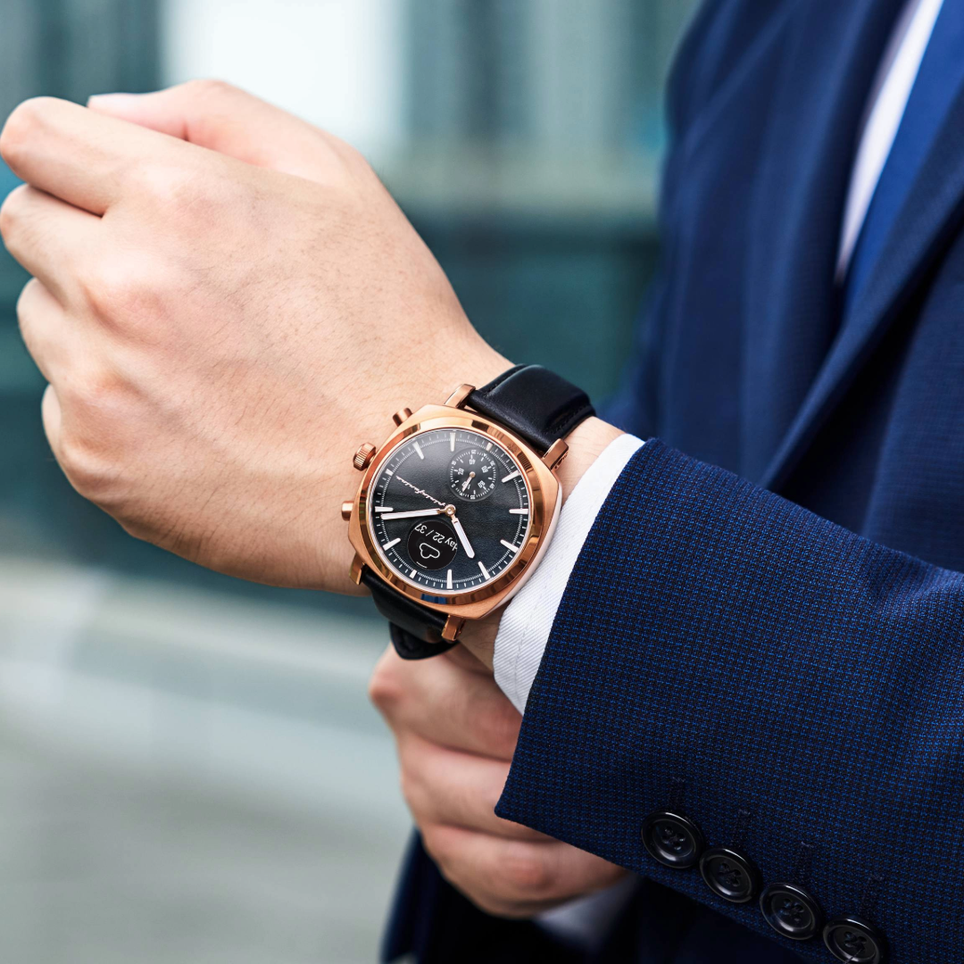 Hand wearing a stylish watch with a blurred background